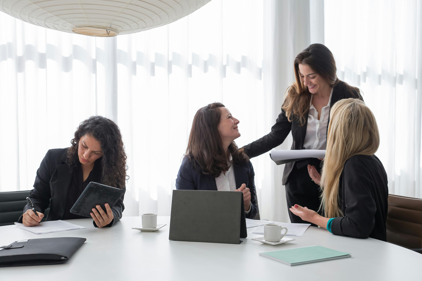 Four professional women meeting in a bright office conference room