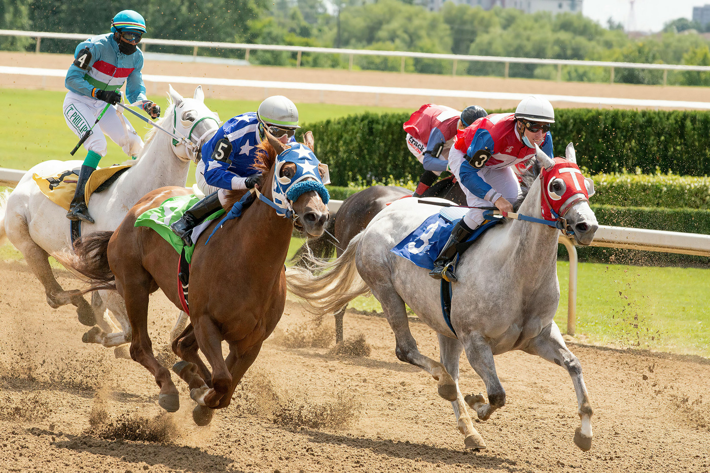 Jockeys racing horses on a dirt track during a competitive race