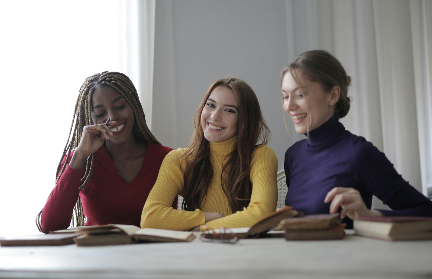 Three women smiling together, representing confidence and progression for female EAs and PAs